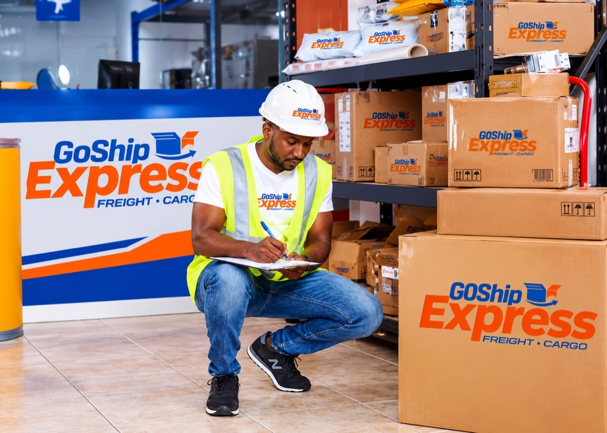 Employé Goship Express contrôlant des colis à l'entrepôt
